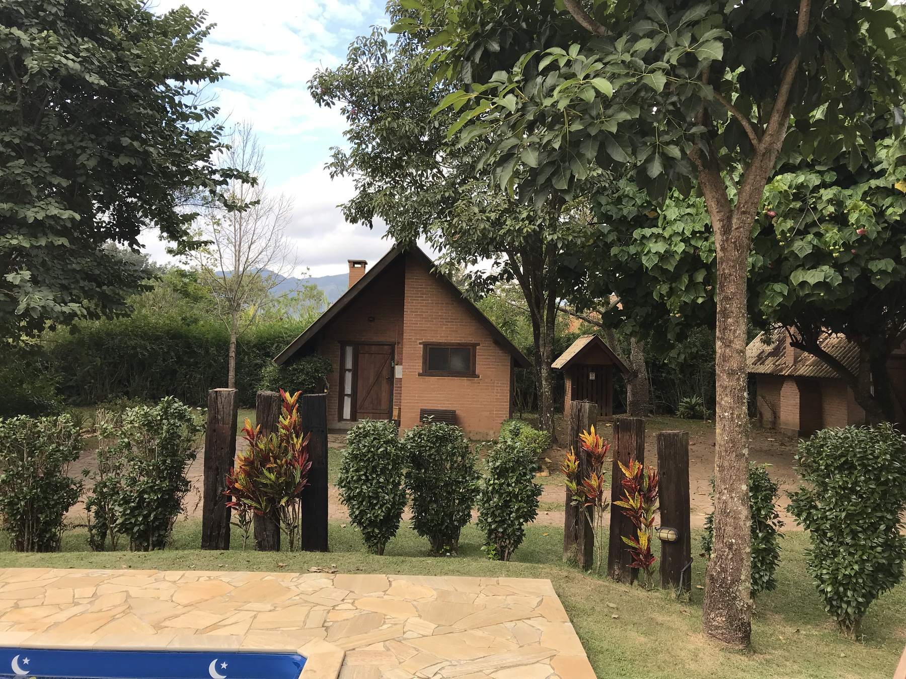 Chalé de tijolo visto da beira da piscina