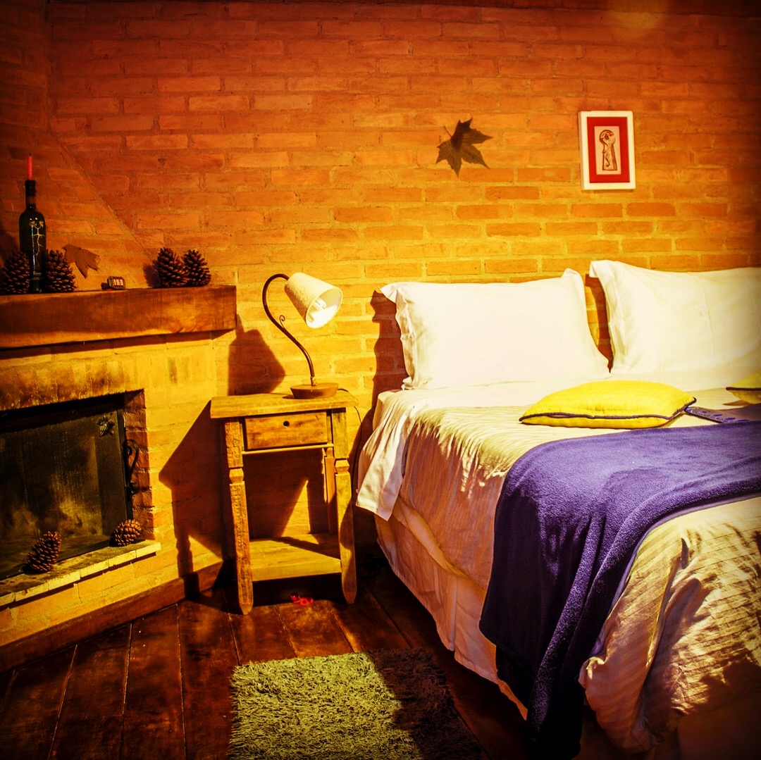 Chalé Eucalipto: cama e lareira sob a luz do abajur