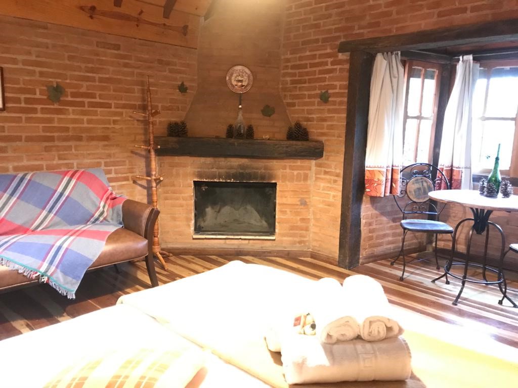 Sofá, lareira e mesa junto à janela